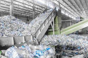 Nahaufnahme Rolltreppe mit einem Haufen Plastikflaschen in der Fabrik für die Verarbeitung und das Recycling. Tierrecyclinganlage foto