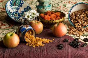 getrocknete Früchte in Tassen auf einer orientalisch verzierten Tischdecke. Stillleben im orientalischen Stil foto