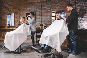 Friseure schneiden ihre Kunden im Friseursalon. Werbe- und Friseurkonzept