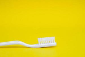 weiße Zahnbürste auf gelbem Hintergrund foto