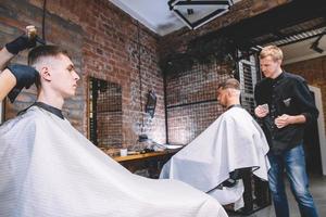 Friseure schneiden ihre Kunden im Friseursalon. Werbe- und Friseurkonzept
