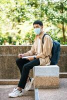 Männer mit Masken sitzen auf der Treppe und lesen Bücher. foto