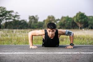 Männer tragen schwarze Hemden mit muskulösen Push-Ups auf der Straße. foto