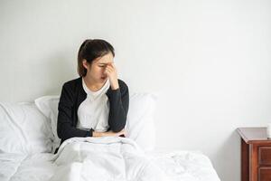 die kranke frau hatte kopfschmerzen und legte ihre hand auf die nase auf das bett. foto