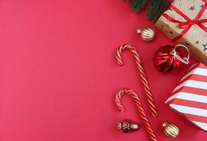 Weihnachtskomposition. Boxen als Geschenk auf Ast Tanne auf rotem Hintergrund. Ansicht von oben, Textfreiraum foto