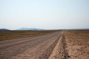 sandige leere Straße, die die namibische Wüste durchquert. Namibia foto