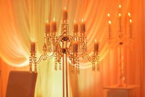 Luxuriöser Hochzeitstisch mit Dekor, mit silbernen Kerzenständern, Kerzen und Blumen in blauem Licht. selektives Foto