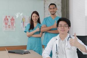 Vertrauensteam des Gesundheitswesens, Porträt von drei jungen Ärzten asiatischer Abstammung in Uniform mit Stethoskop, lächelnd und mit Blick auf die Kamera in der Klinik, Personen, die sich mit professioneller Behandlung auskennen. foto