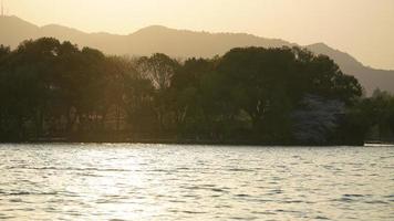 die wunderschönen Seenlandschaften in der chinesischen Stadt Hangzhou im Frühling mit dem Sonnenuntergangssonnenlicht foto