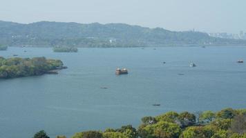 die wunderschönen Seenlandschaften in der chinesischen Stadt Hangzhou im Frühling mit dem friedlichen See und den frischen grünen Bergen foto