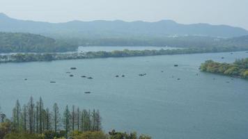 die wunderschönen Seenlandschaften in der chinesischen Stadt Hangzhou im Frühling mit dem friedlichen See und den frischen grünen Bergen foto