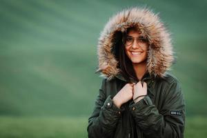 Porträt einer Frau, die sich im Winter auf grüner Wiese kalt fühlt foto