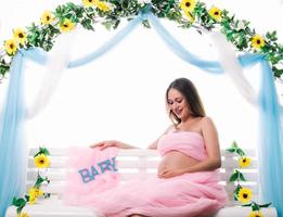 junge schöne schwangere frau posiert. auf ihren bauch schauen foto