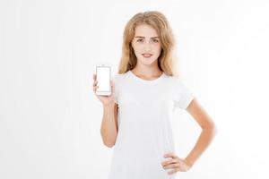 Mädchen, Frau im T-Shirt mit leerem Bildschirm-Handy isoliert auf weißem Hintergrund. Smartphone am Arm halten, Platz kopieren foto