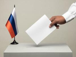 Wahlurne mit nationaler Flagge Russlands. Präsidentschaftswahlen im Jahr 2018. Hand wirft einen Stimmzettel foto