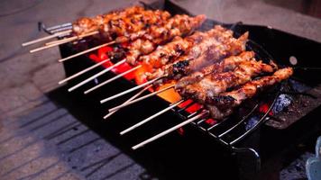 der Prozess der Herstellung von Satay-Essen, gegrillt über Holzkohle foto