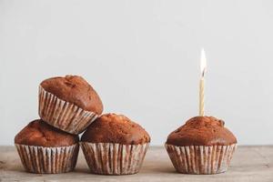 Schokoladen-Cupcakes mit Kerze auf Holztisch foto