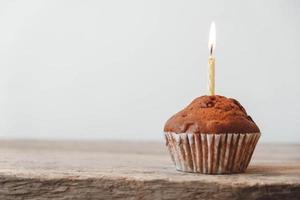 Schokoladen-Cupcake mit Kerze auf Holztisch foto