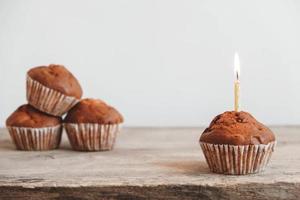 Schokoladen-Cupcakes mit Kerze auf Holztisch foto