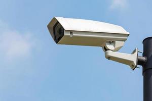 einzelne CCTV-Überwachungskamera auf klarem Himmelshintergrund foto