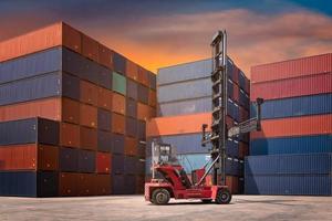 Gabelstapler und Frachtcontainer im Versandhof für Transportimport, -export, Logistikindustrie mit Containerstapel im Hintergrund foto