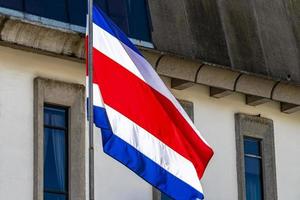 Flagge von Costa Rica alte Gebäude hinter costa-ricanischer Flagge. foto