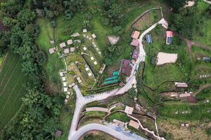 Luftaufnahme des Hüttenresorts am Hang zwischen den Bergen im tropischen Regenwald an regnerischen Tagen foto