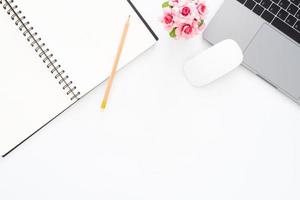kreatives flaches Laienfoto des Arbeitsplatzschreibtisches. Schreibtisch von oben mit Laptop, Bleistift, Notizbuch und Pflanze auf weißem Hintergrund. Draufsicht mit Kopienraum, Flachfotografie. foto