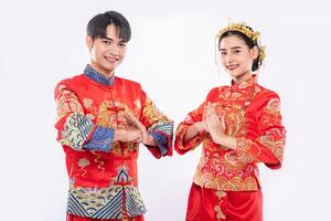 Männer und Frauen tragen Qipao, um ihren Respekt zu erweisen. isoliert auf weißem Hintergrund foto