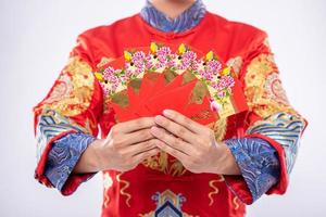Mann trägt Cheongsam-Anzug gibt seiner Familie ein Geschenk, um im chinesischen Neujahr ein glücklicher Mensch zu sein foto