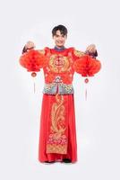 Mann trägt Cheongsam-Anzug-Show, dekorieren rote Lampe in seinem Geschäft im chinesischen Neujahr