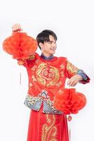 Mann trägt Cheongsam-Anzug-Show, dekorieren rote Lampe in seinem Geschäft im chinesischen Neujahr