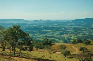 Pardinho, Brasilien - 31. Mai 2018. Blick auf Wiesen und Bäume in einem grünen Tal mit bergiger Landschaft, an einem sonnigen Tag in der Nähe von Pardinho. ein kleines ländliches dorf auf dem land des staates são paulo. foto