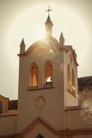 Fassade der kleinen Kirche und des Glockenturms mit Sonnenschein hinter bei Sonnenuntergang in Sao Manuel. eine süße kleine stadt auf dem land des bundesstaates são paulo. Südost brasilien. foto