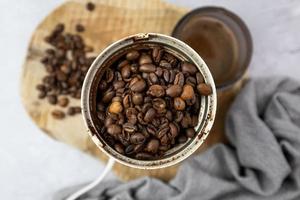 ganze Kaffeebohnen in einer elektrischen Kaffeemühle. Ansicht von oben. foto