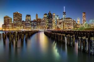 Lower Manhattan und ein alter Brooklyn Pier in der Abenddämmerung