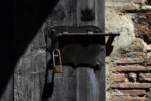 schwarzes und braunes Vorhängeschloss an schwarzer Holztür foto