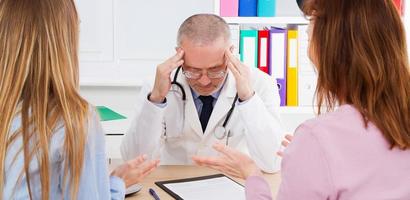 Arzt und zwei Patienten im Klinikbüro foto