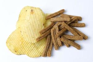 Chips und Cracker auf weißem Hintergrund.