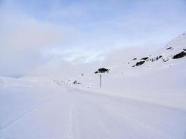 Fahren durch verschneite Straße und Landschaft in Norwegen. foto