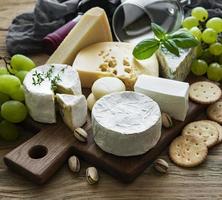 verschiedene Arten von Käse, Trauben und Wein foto
