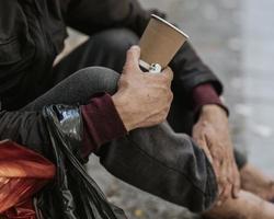 Seitenansicht Obdachloser mit Tasse foto