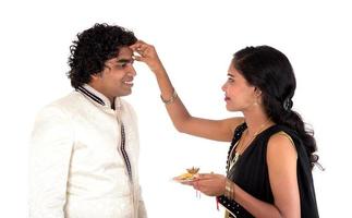 Indische junge Schwester, die Rakhi am Handgelenk des Bruders bindet, eine Tradition auf dem Raksha-Bandhan-Festival foto