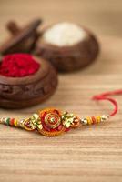 indischer Festival-Raksha-Bandhan-Hintergrund mit einem eleganten Rakhi, Reiskörnern und Kumkum. ein traditionelles indisches Armband, das ein Symbol der Liebe zwischen Brüdern und Schwestern ist. foto