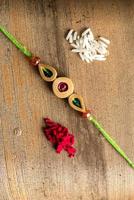 indischer Festival-Raksha-Bandhan-Hintergrund mit einem eleganten Rakhi, Reiskörnern und Kumkum. ein traditionelles indisches Armband, das ein Symbol der Liebe zwischen Brüdern und Schwestern ist. foto