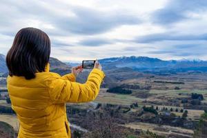 Asiatische Touristenfrau, die Foto mit Handy in Queenstown Südinsel Neuseeland macht