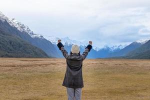 junger asiatischer Reisender feiert Erfolg im eglinton Valley, Te Anua, Südinsel, Neuseeland foto