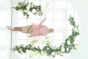 Schönes islamisches weibliches Modell mit Hijab-Mode, einem modernen Lifestyle-Outfit für muslimische Frauen. Konzept ein Hochzeitskleid, Schönheit oder Eidul Fitri. ein asiatisches Mädchenmodell mit Hijab bei einem Indoor-Fotoshooting foto