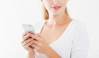 7/8-Porträt einer lächelnden jungen Frau mit Handy isoliert auf weißem Hintergrund, Chat-Mädchen, Werbekonzept, Textfreiraum
