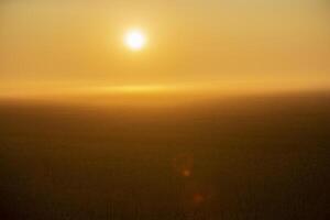 verschwommen Hintergrund Feld beim Sonnenuntergang mit das Sonne foto